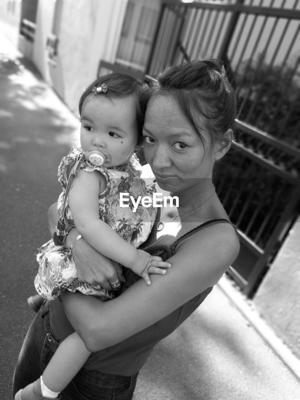 Portrait of woman with daughter standing on street