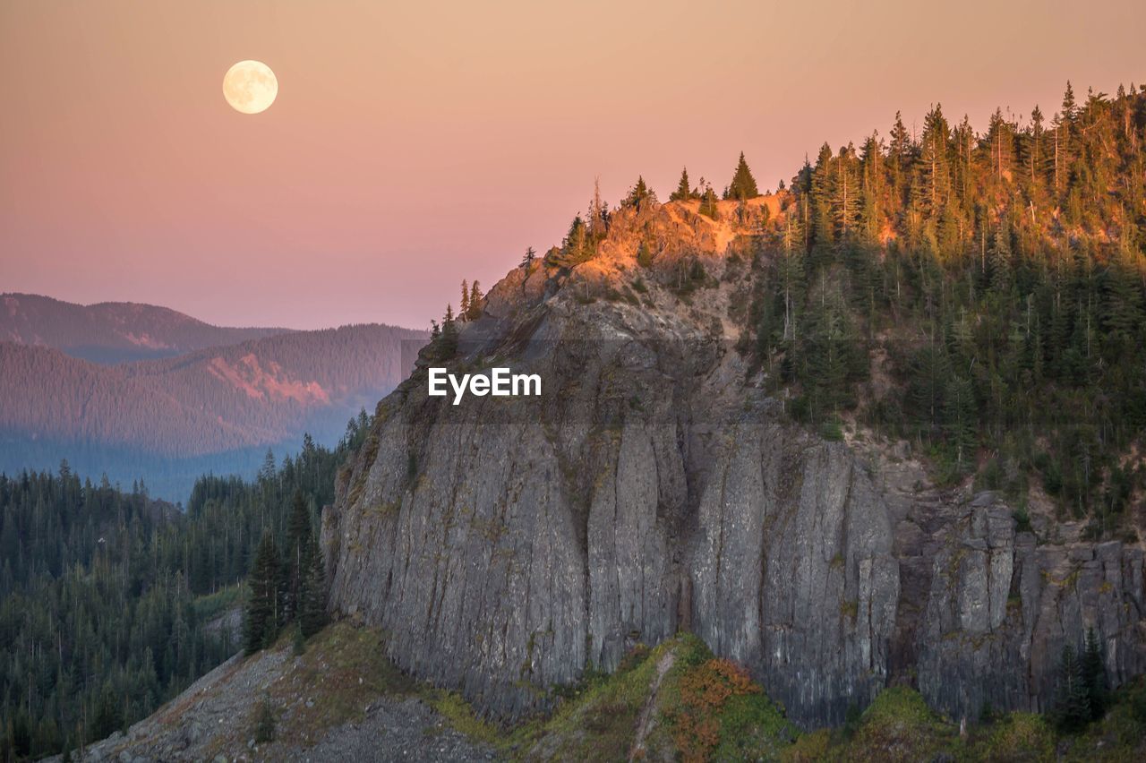 Scenic view of mountains against full moon during sunset
