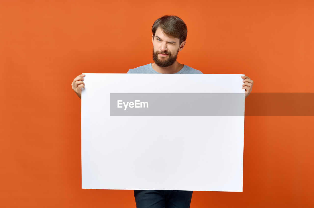 PORTRAIT OF MAN STANDING AGAINST WHITE BACKGROUND