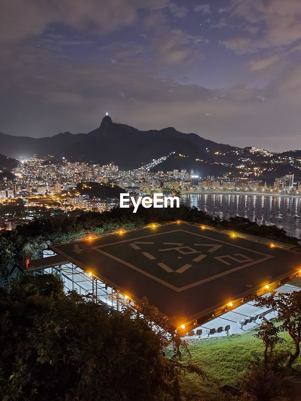 HIGH ANGLE VIEW OF ILLUMINATED CITY BUILDINGS AT NIGHT