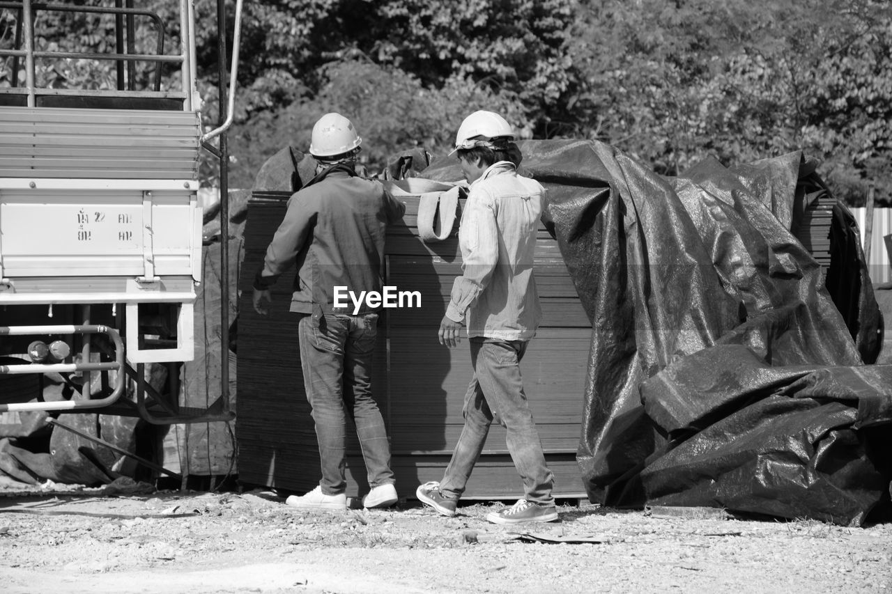 REAR VIEW OF PEOPLE WORKING IN CONSTRUCTION SITE