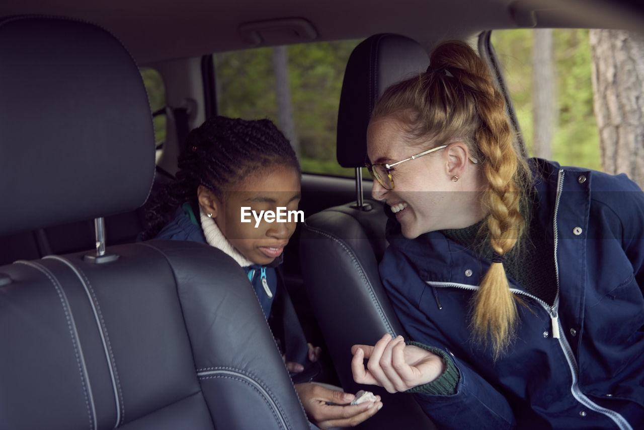 Smiling woman sitting with daughter in car