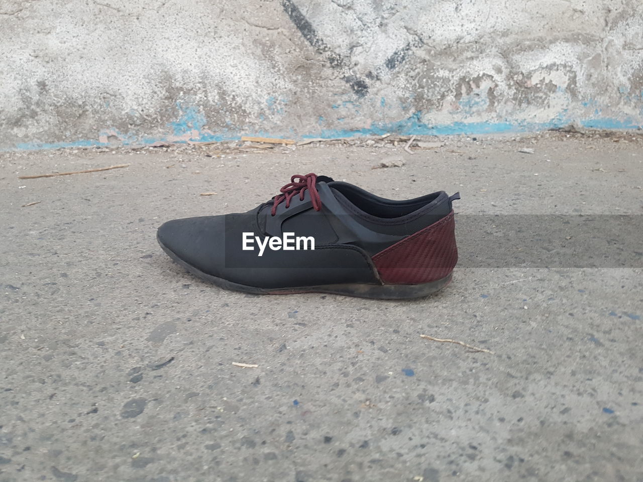 High angle view of shoe on sand on sidewalk 