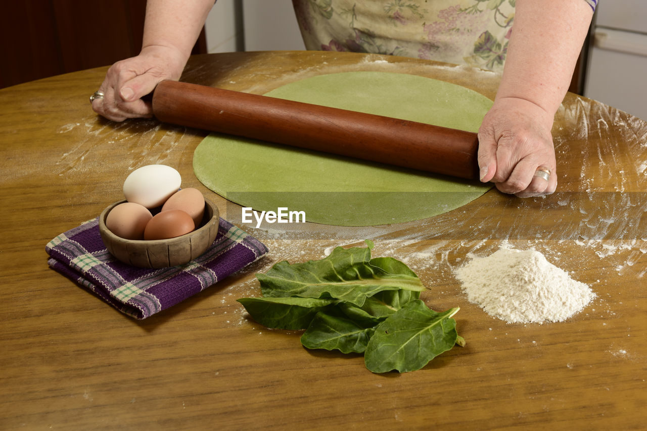 high angle view of woman holding food on cutting board