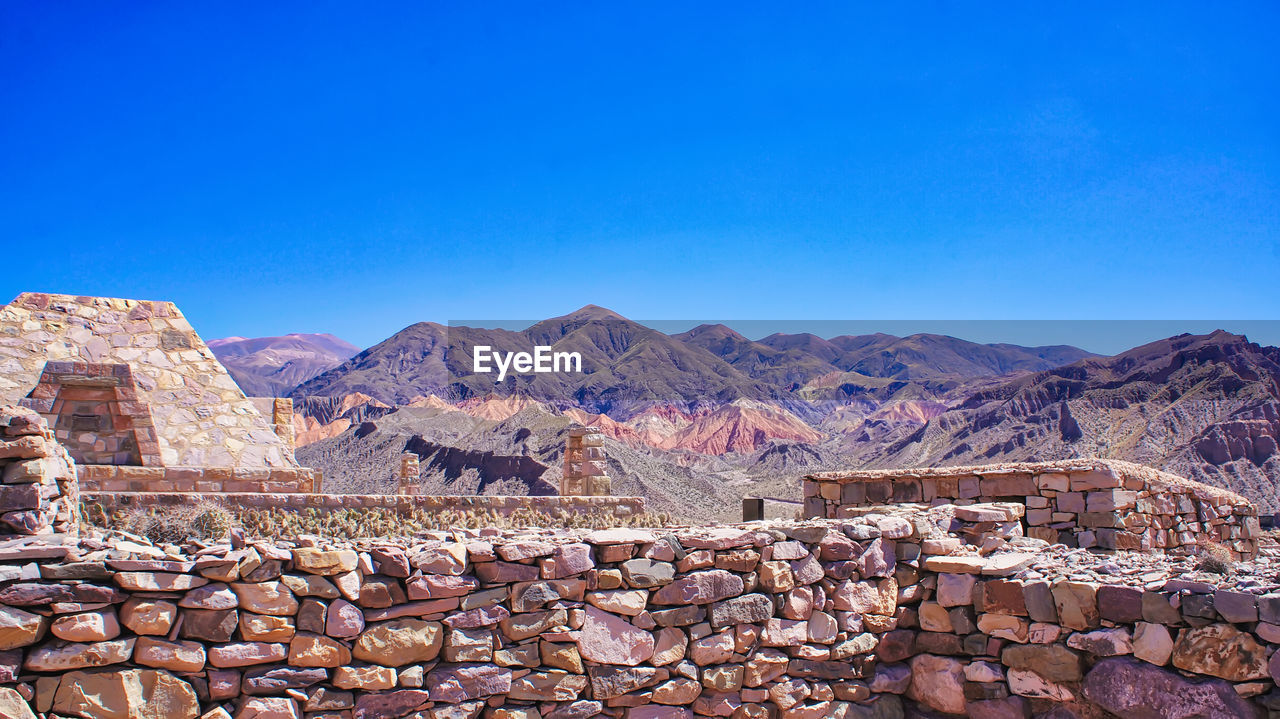 AERIAL VIEW OF MOUNTAINS AGAINST BLUE SKY