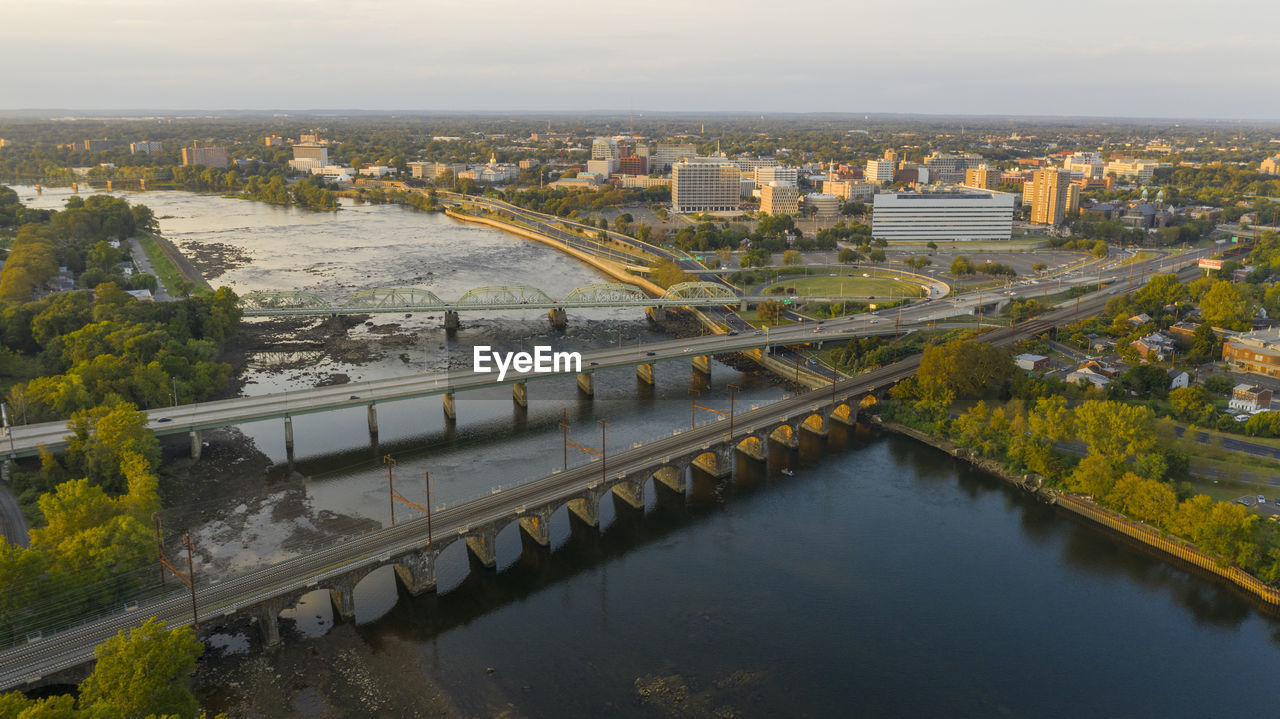 HIGH ANGLE VIEW OF RIVER AMIDST BUILDINGS AGAINST SKY