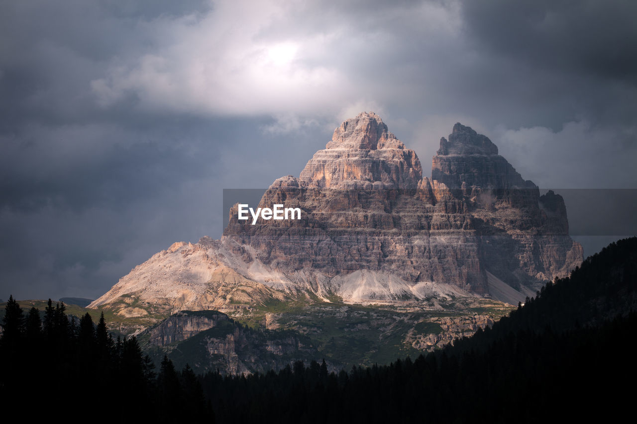 Low angle view of mountain range against cloudy sky