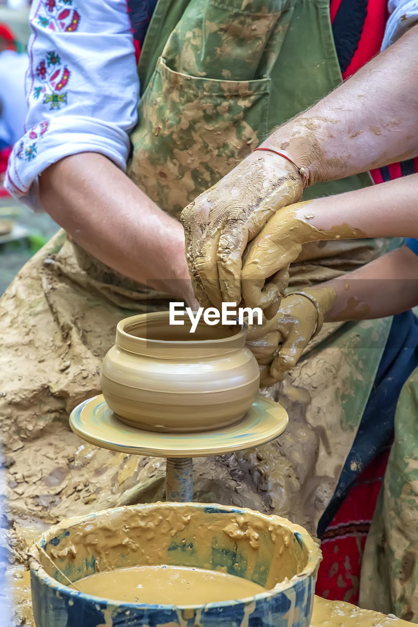 Close-up of hands making pottery