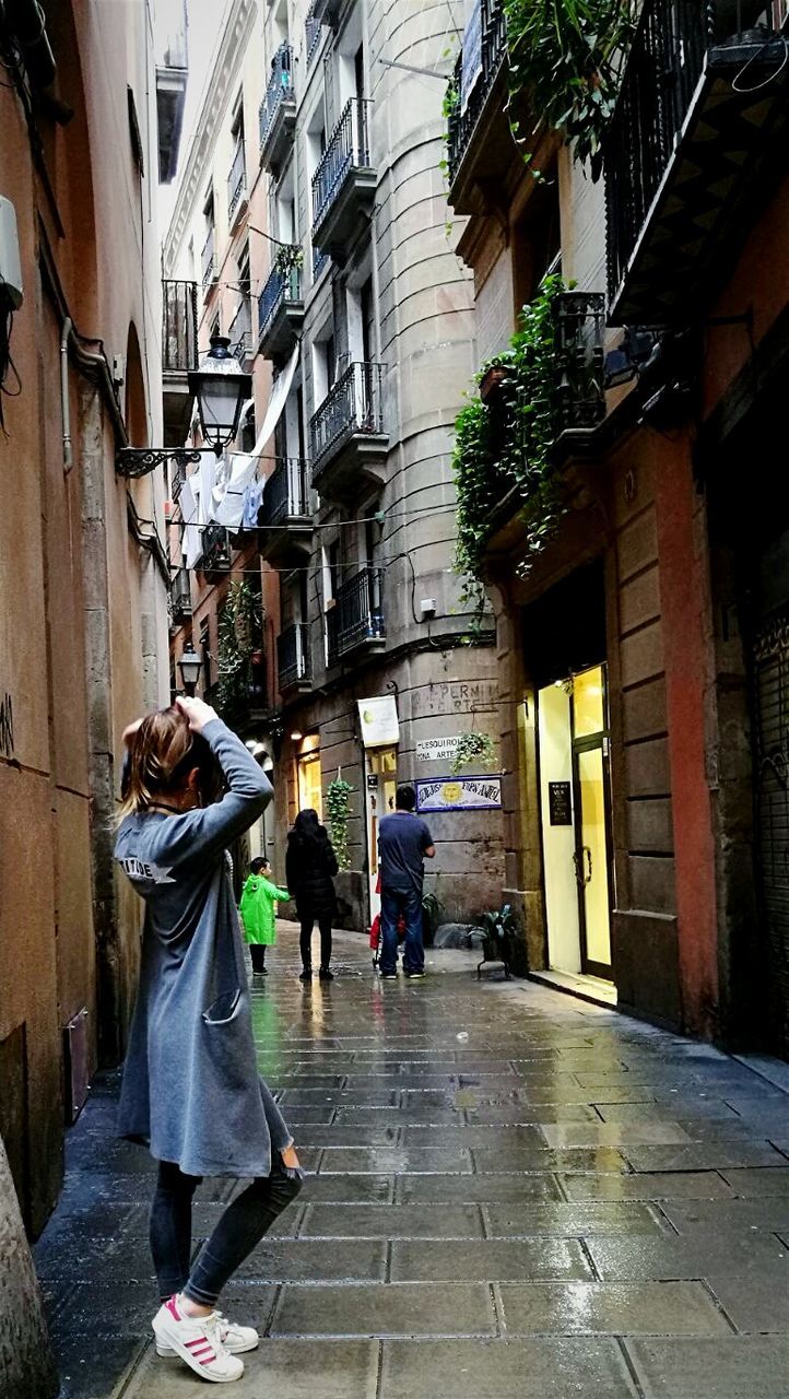 PEOPLE WALKING ON STREET ALONG BUILDINGS