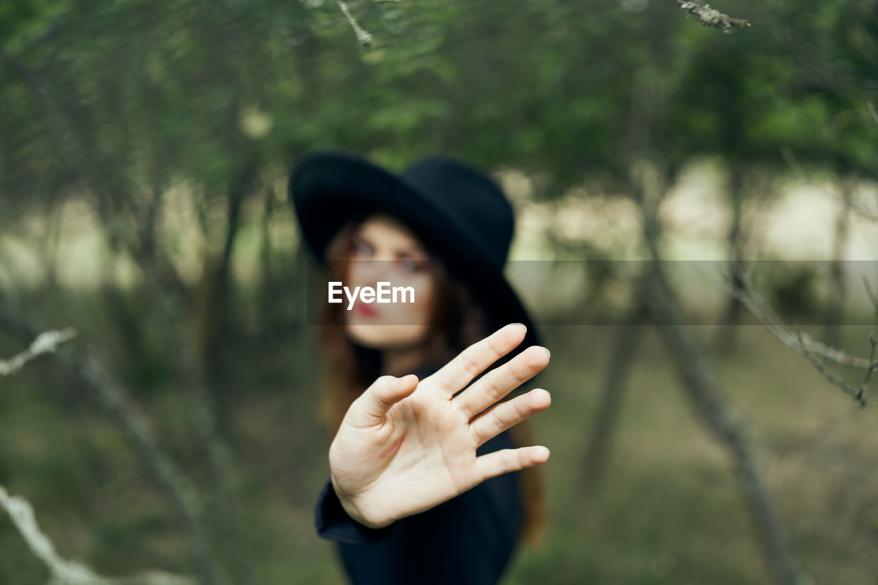 side view of woman looking away against trees