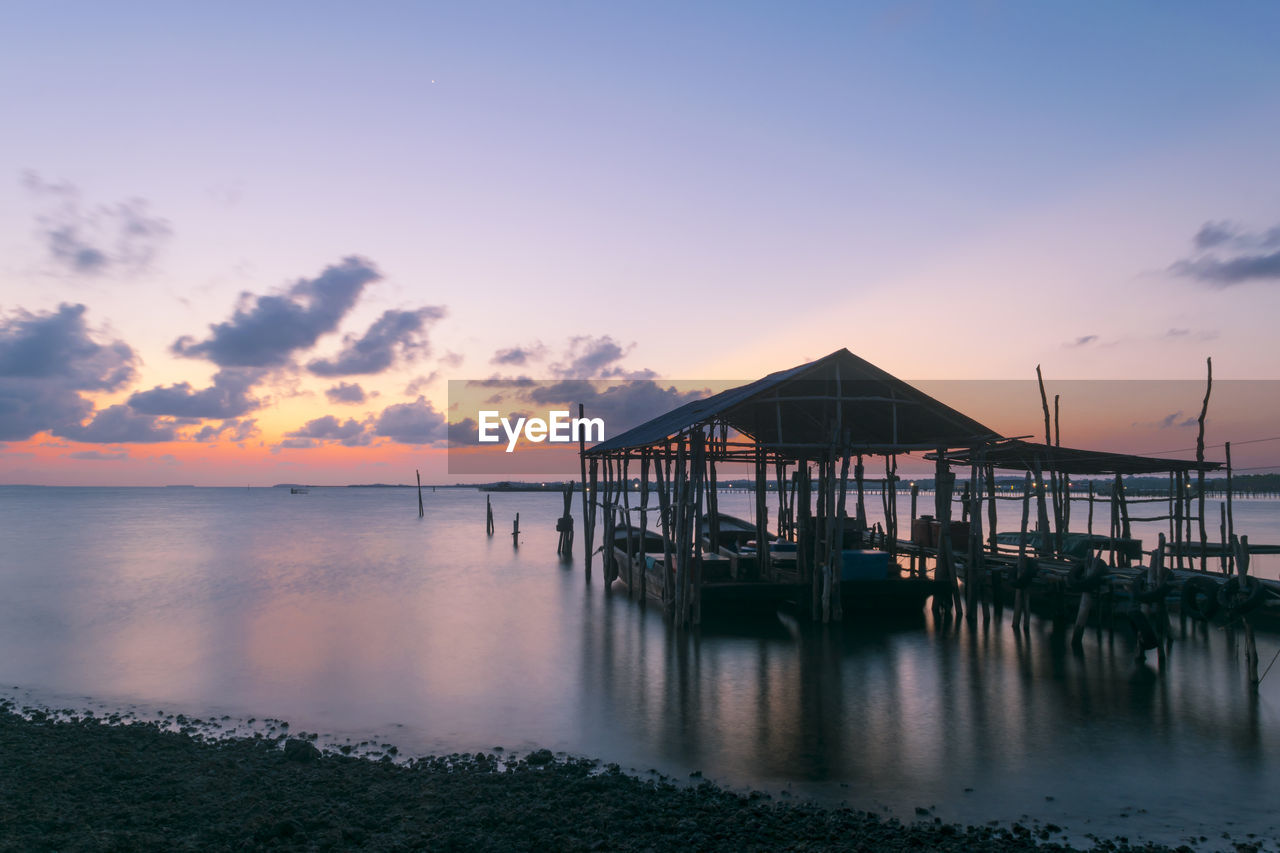 PIER OVER SEA AGAINST SKY DURING SUNSET