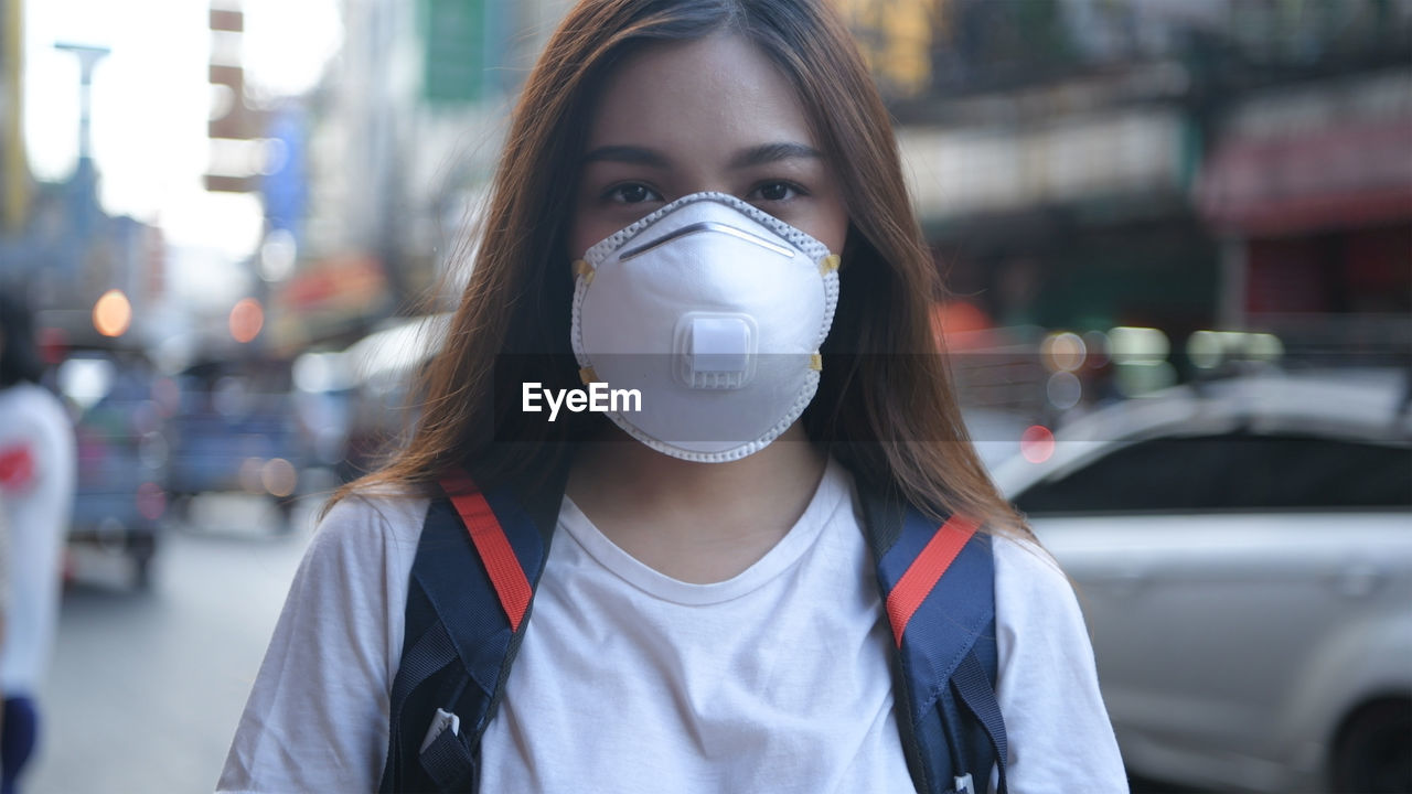 Young woman wearing protective mask in city
