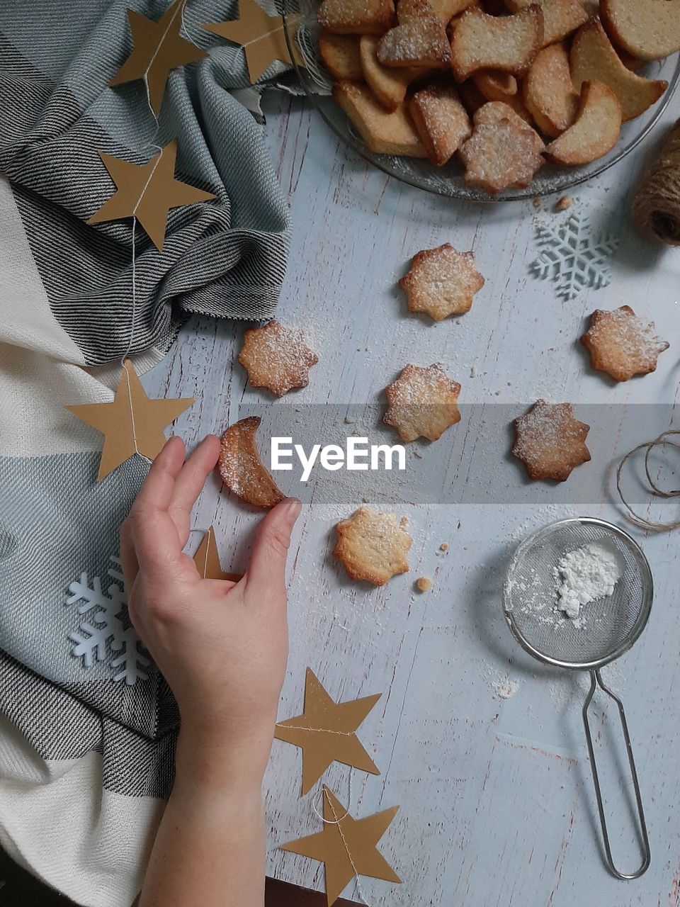 High angle view of hand holding cookies on table