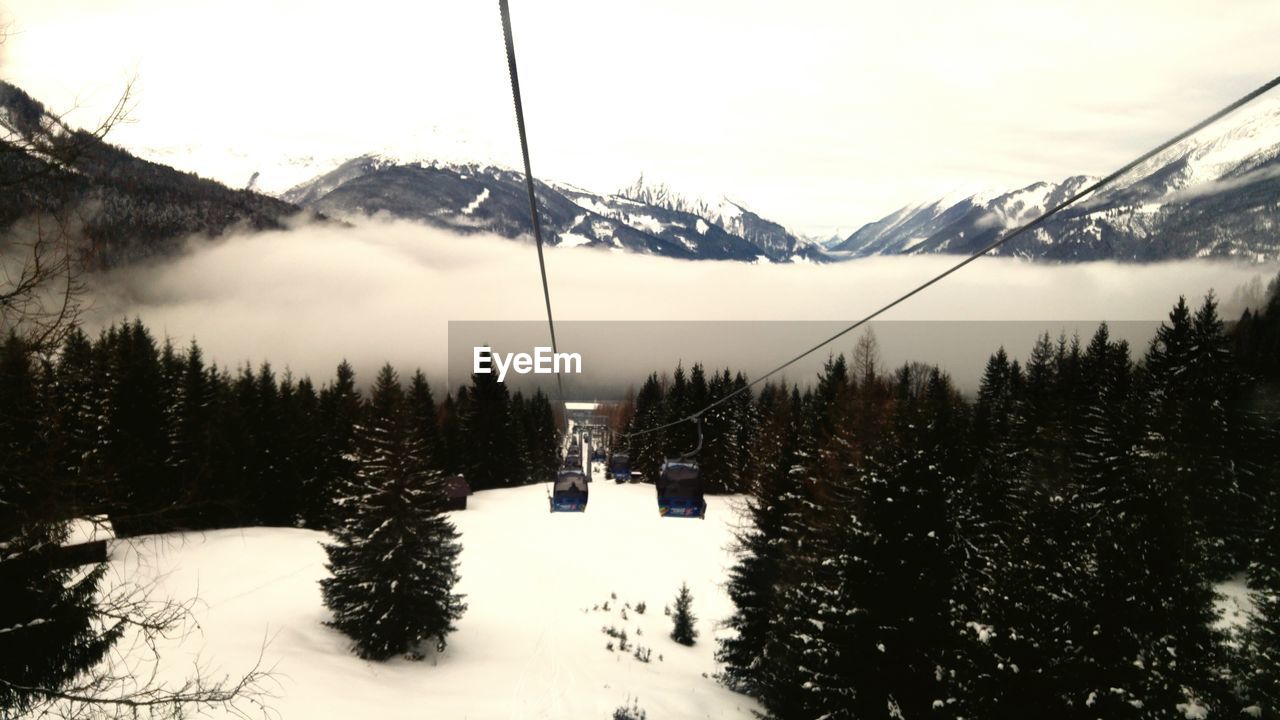 Ski lifts moving over snow covered valley