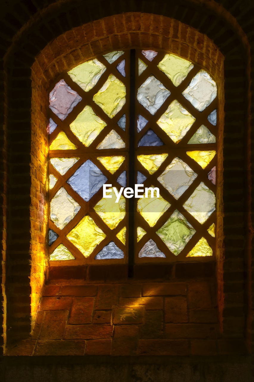 LOW ANGLE VIEW OF ORNATE WINDOW IN OLD BUILDING