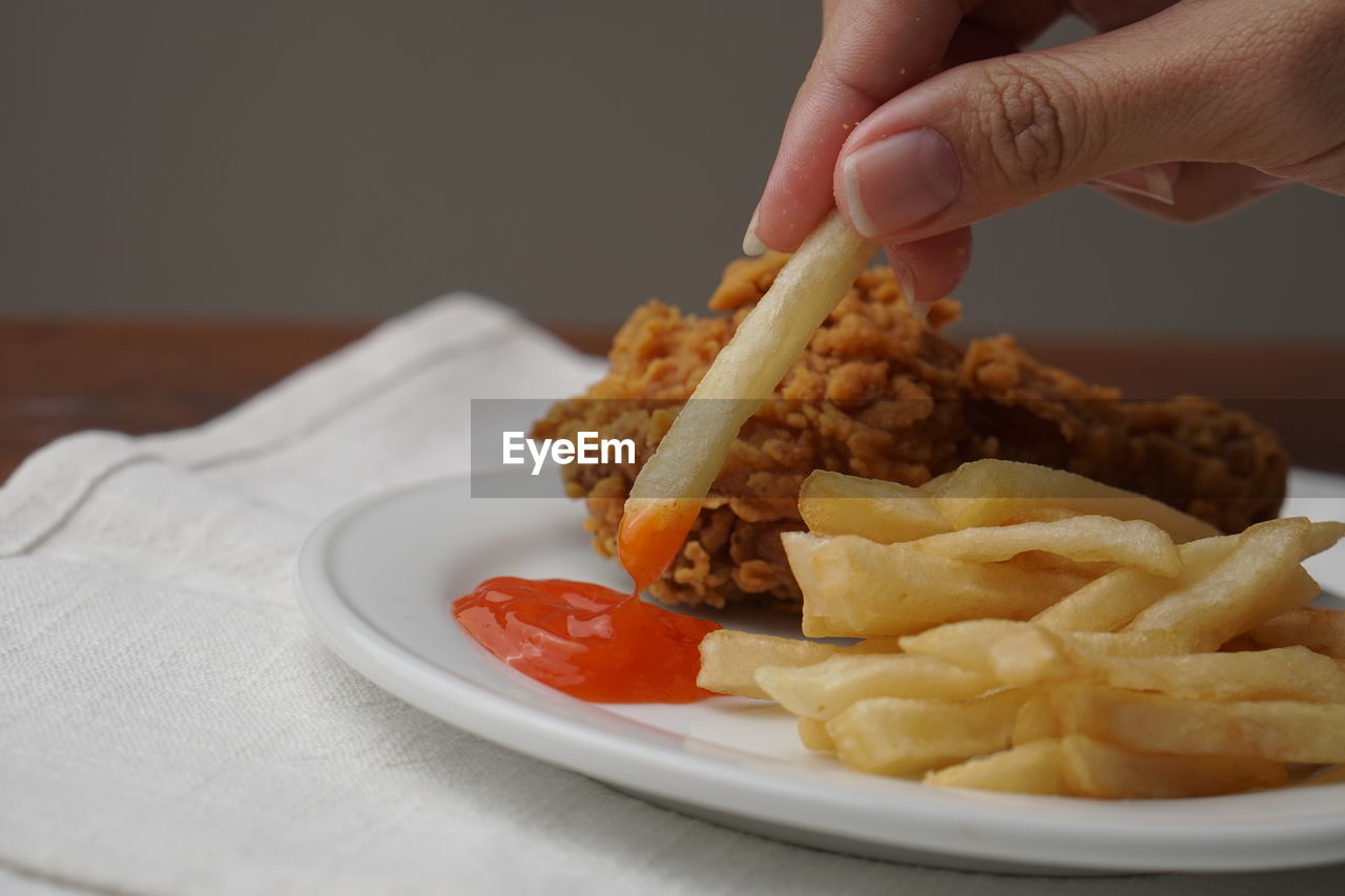 food, food and drink, hand, dish, raw potato, fast food, one person, french fries, fried, unhealthy eating, fried food, meal, breakfast, produce, indoors, plate, cuisine, snack, junk food, meat, close-up, condiment, ketchup, freshness, holding, vegetarian food, adult, eating