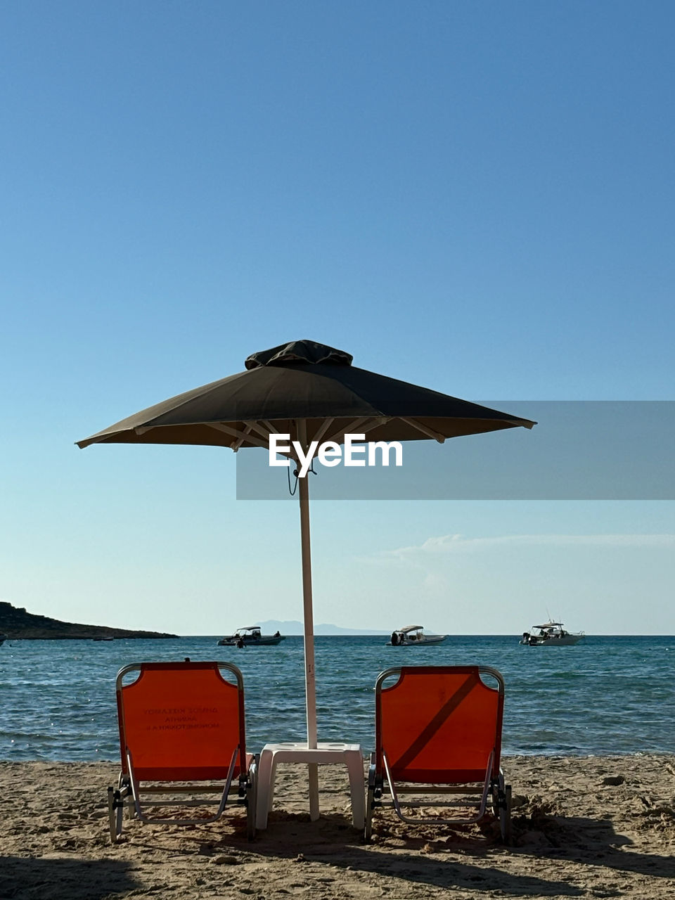 water, beach, sea, land, sky, umbrella, nature, ocean, sand, chair, parasol, clear sky, protection, tranquility, coast, horizon over water, beauty in nature, blue, tranquil scene, beach umbrella, vacation, scenics - nature, horizon, trip, shade, sunny, holiday, sunshade, body of water, security, summer, shore, seat, day, no people, sunlight, travel destinations, travel, relaxation, outdoors, idyllic, lounge chair, absence, copy space, lifeguard, coastline, non-urban scene