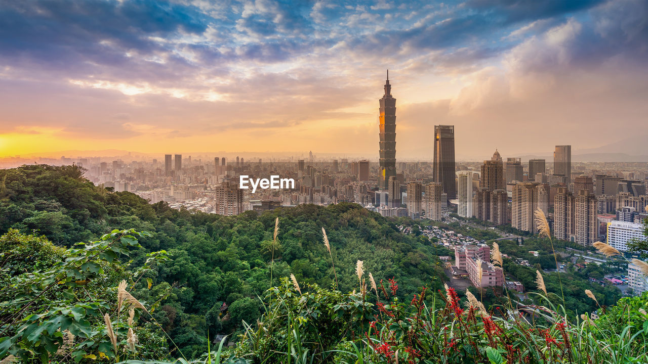 PANORAMIC VIEW OF BUILDINGS AGAINST CLOUDY SKY