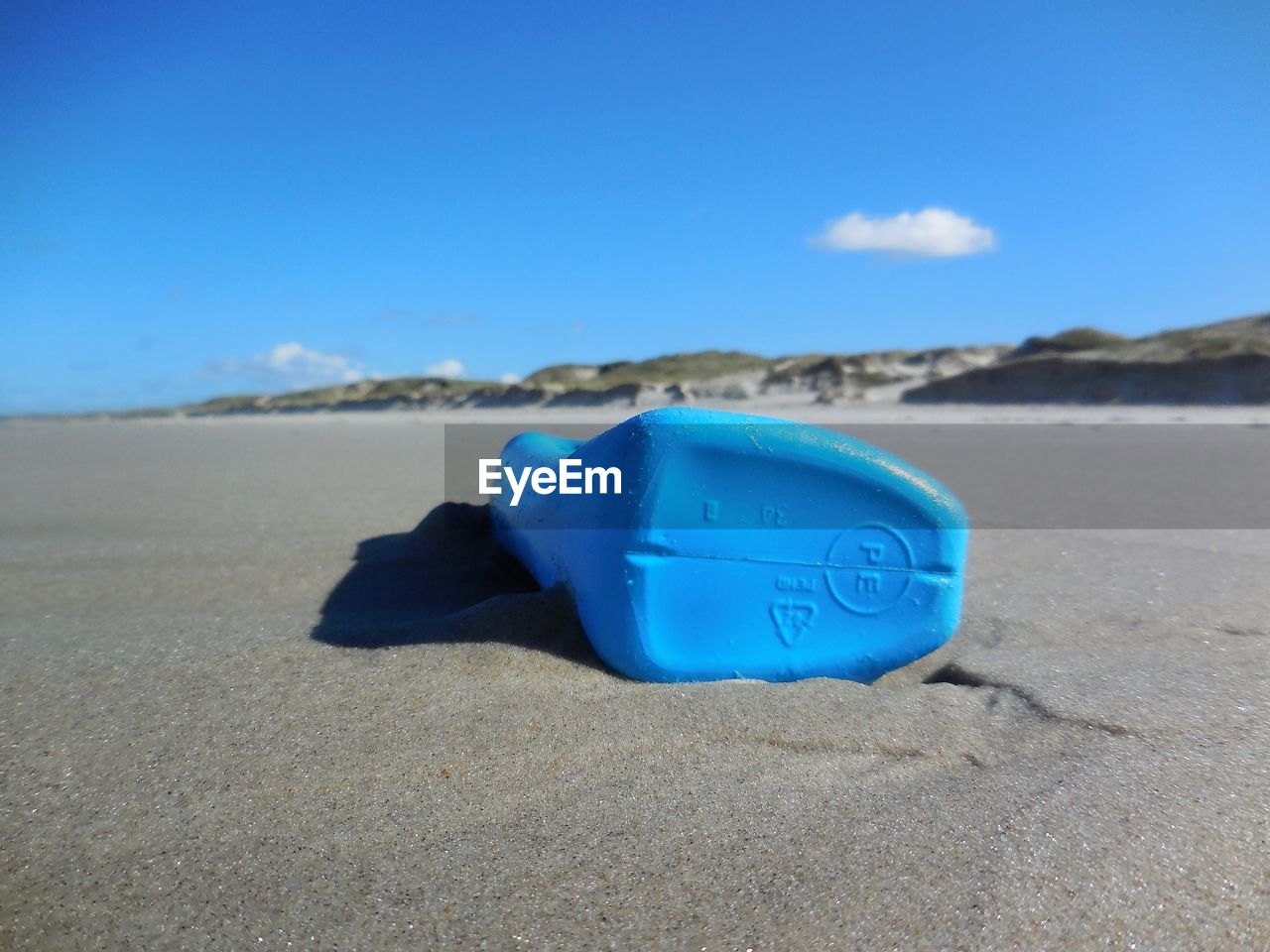 Blue container on beach against sky