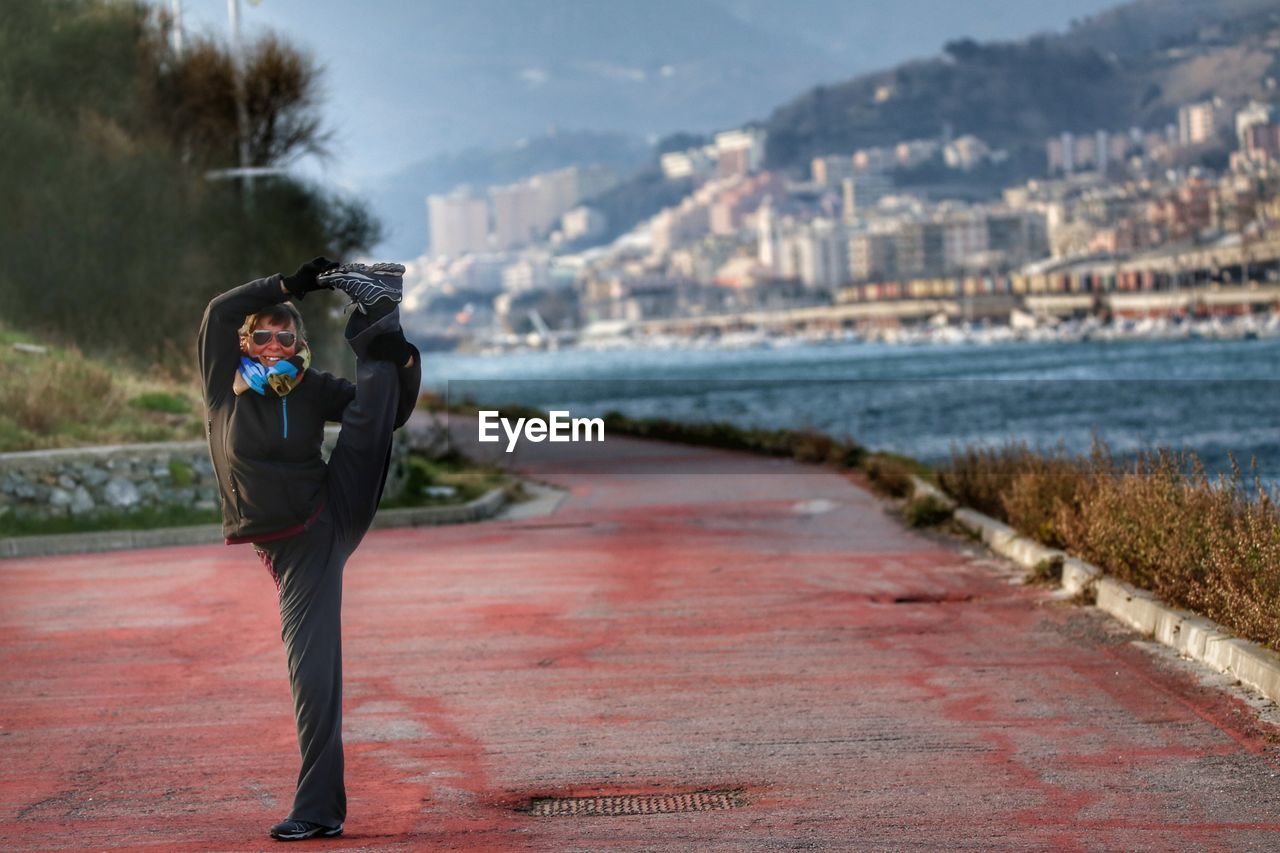 Woman standing on one leg at promenade