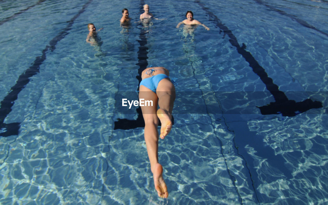 HIGH ANGLE VIEW OF WOMAN SWIMMING IN POND