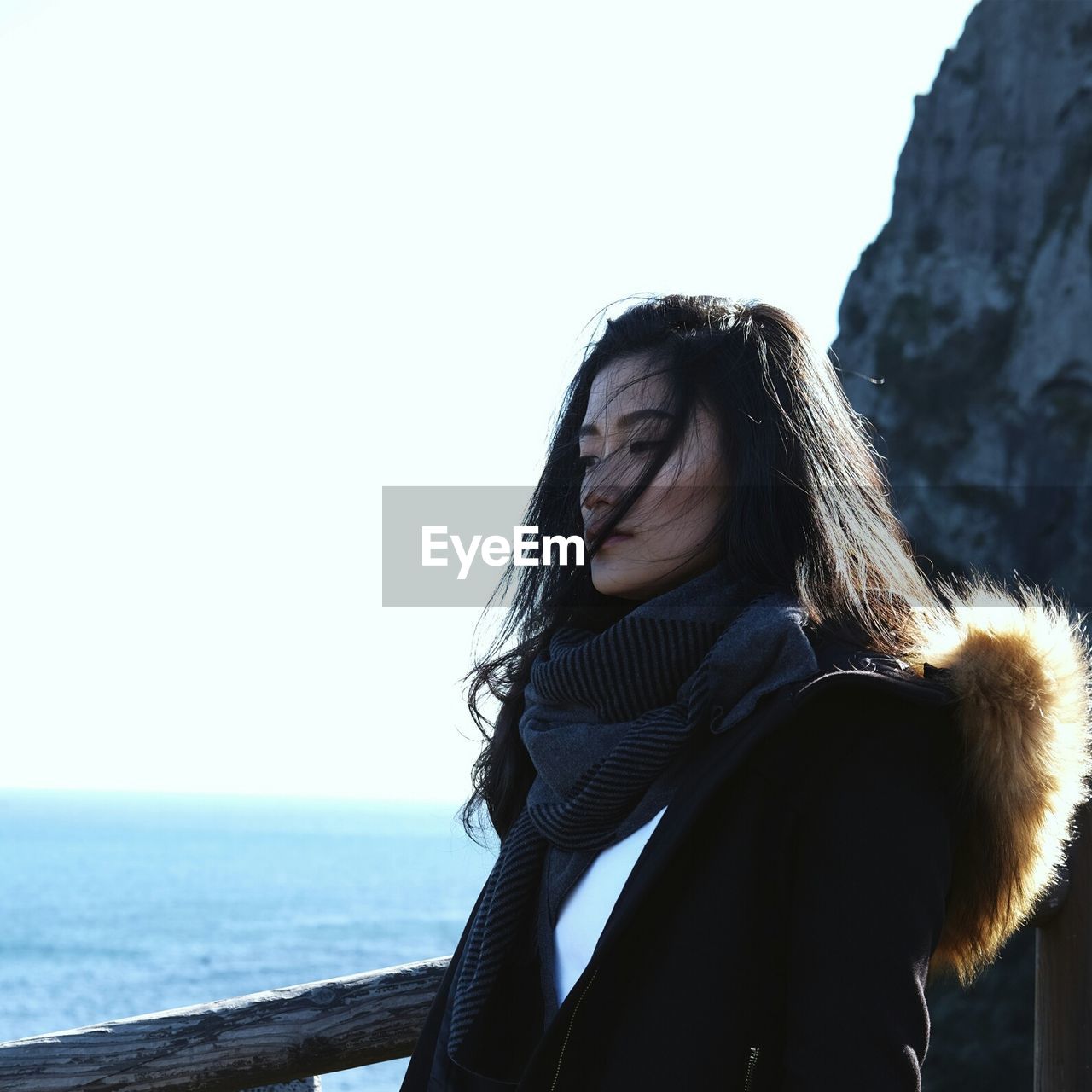 Young woman looking at sea against clear sky