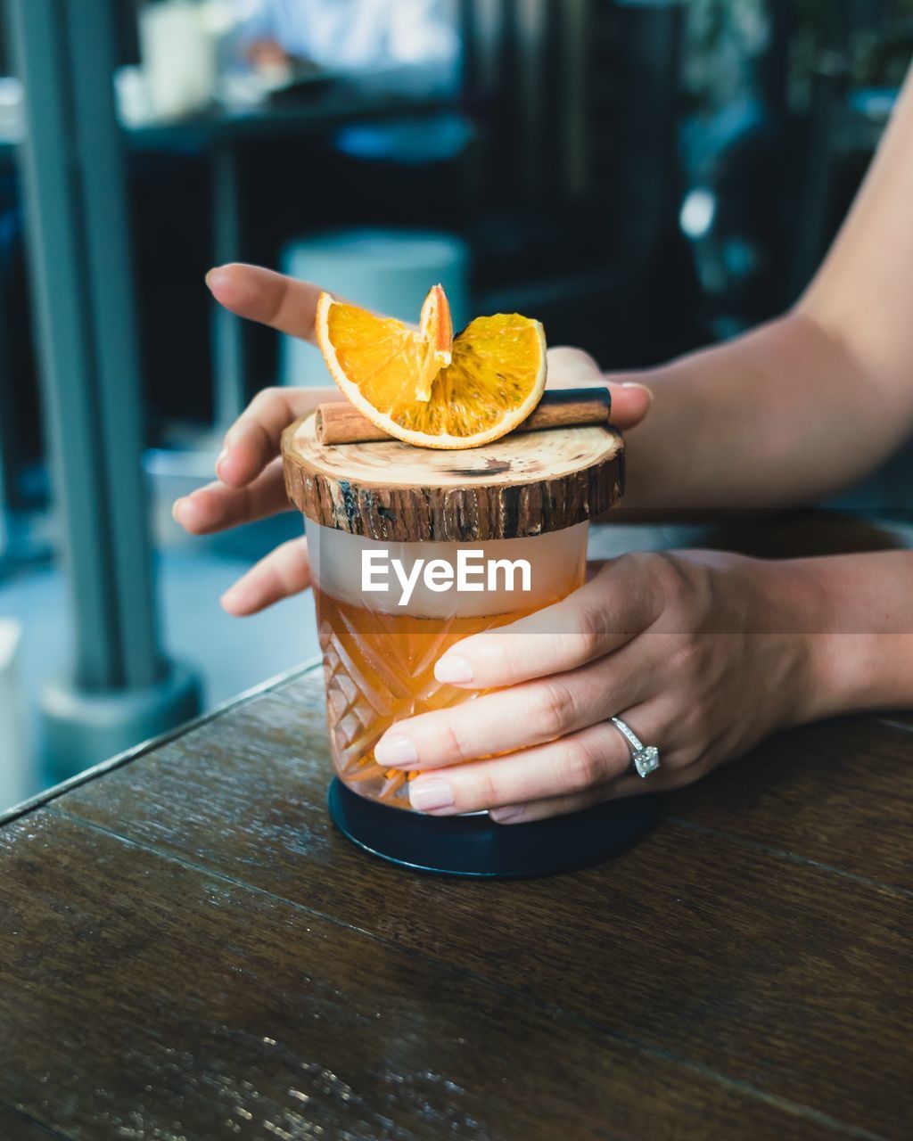 Cropped hands of woman having drink at table