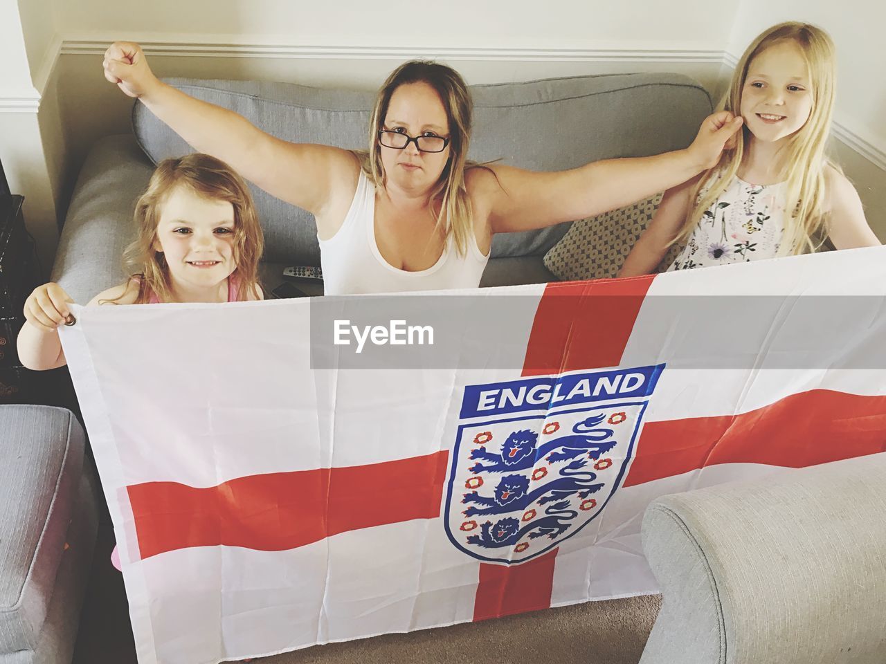 Portrait of woman with daughters holding english flag