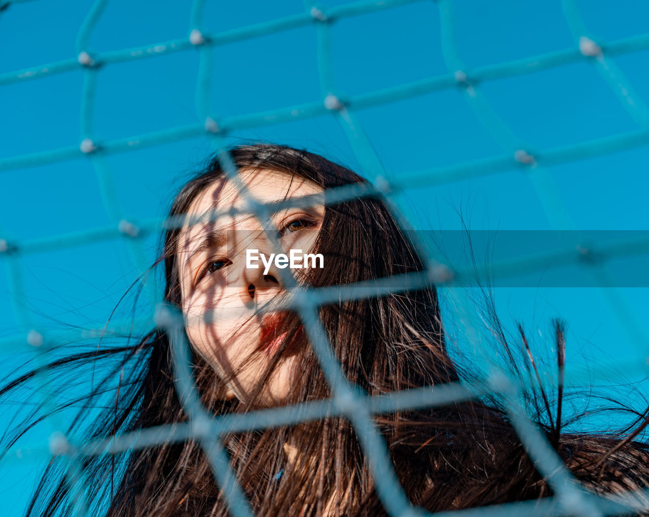 Low angle view of woman seen through net