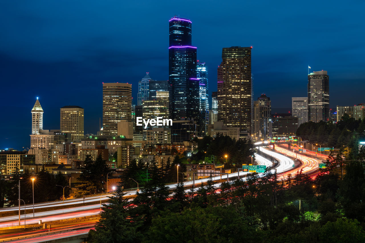 Illuminated buildings in city against sky at night