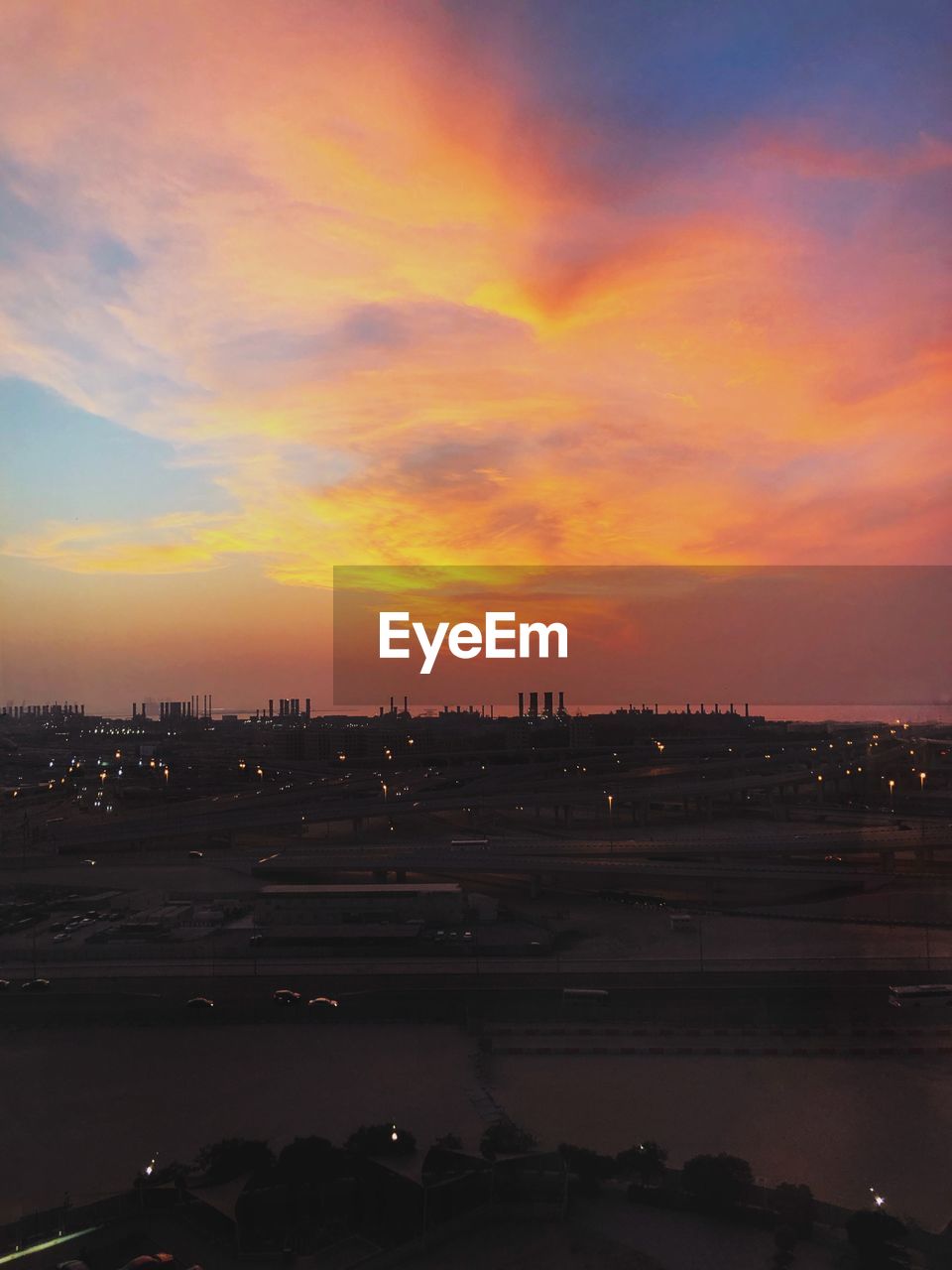 SCENIC VIEW OF SILHOUETTE BUILDINGS AGAINST DRAMATIC SKY DURING SUNSET