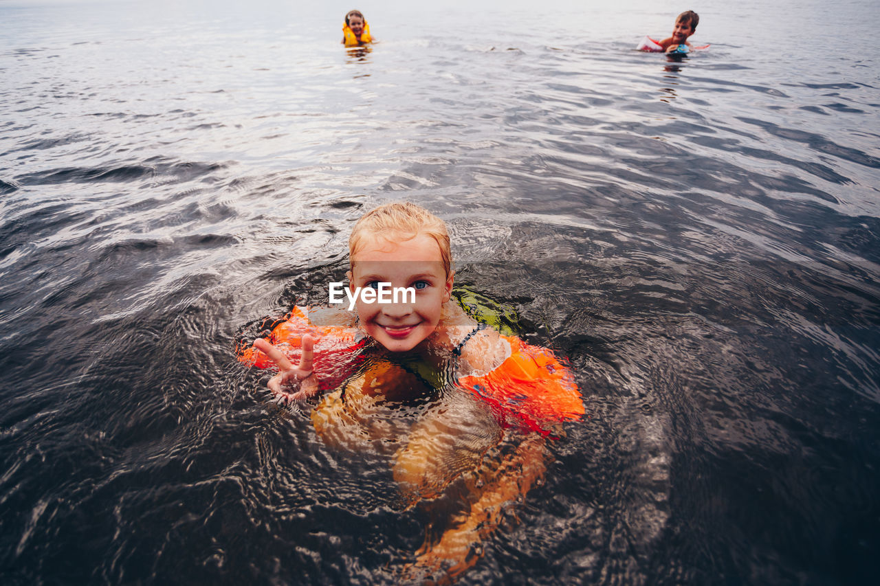 HIGH ANGLE VIEW PORTRAIT OF SMILING SWIMMING IN WATER