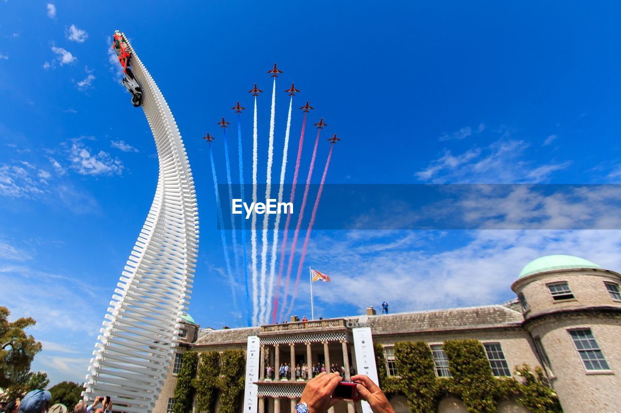 Low angle view of modern sculpture in front of goodwood house with airshow