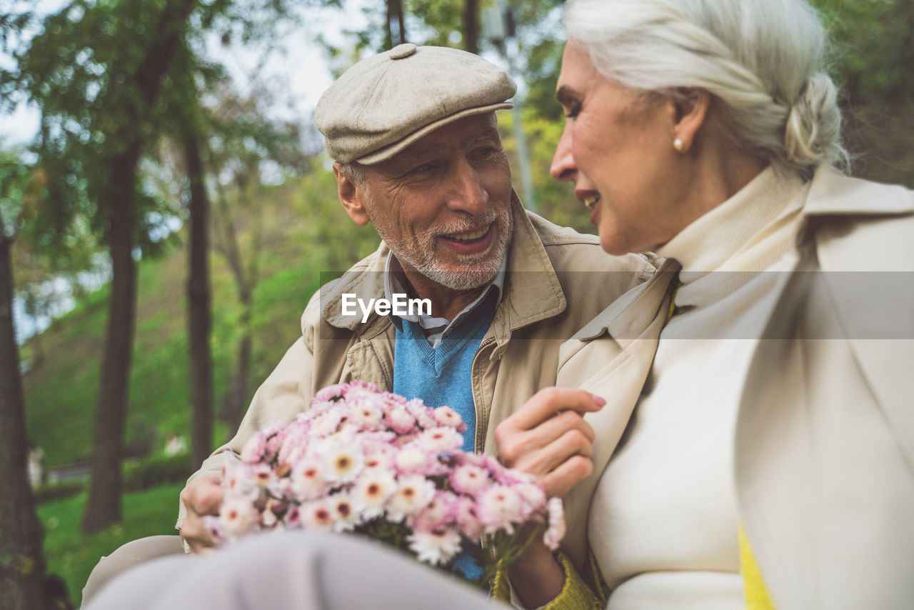 Laughing senior couple sitting at park