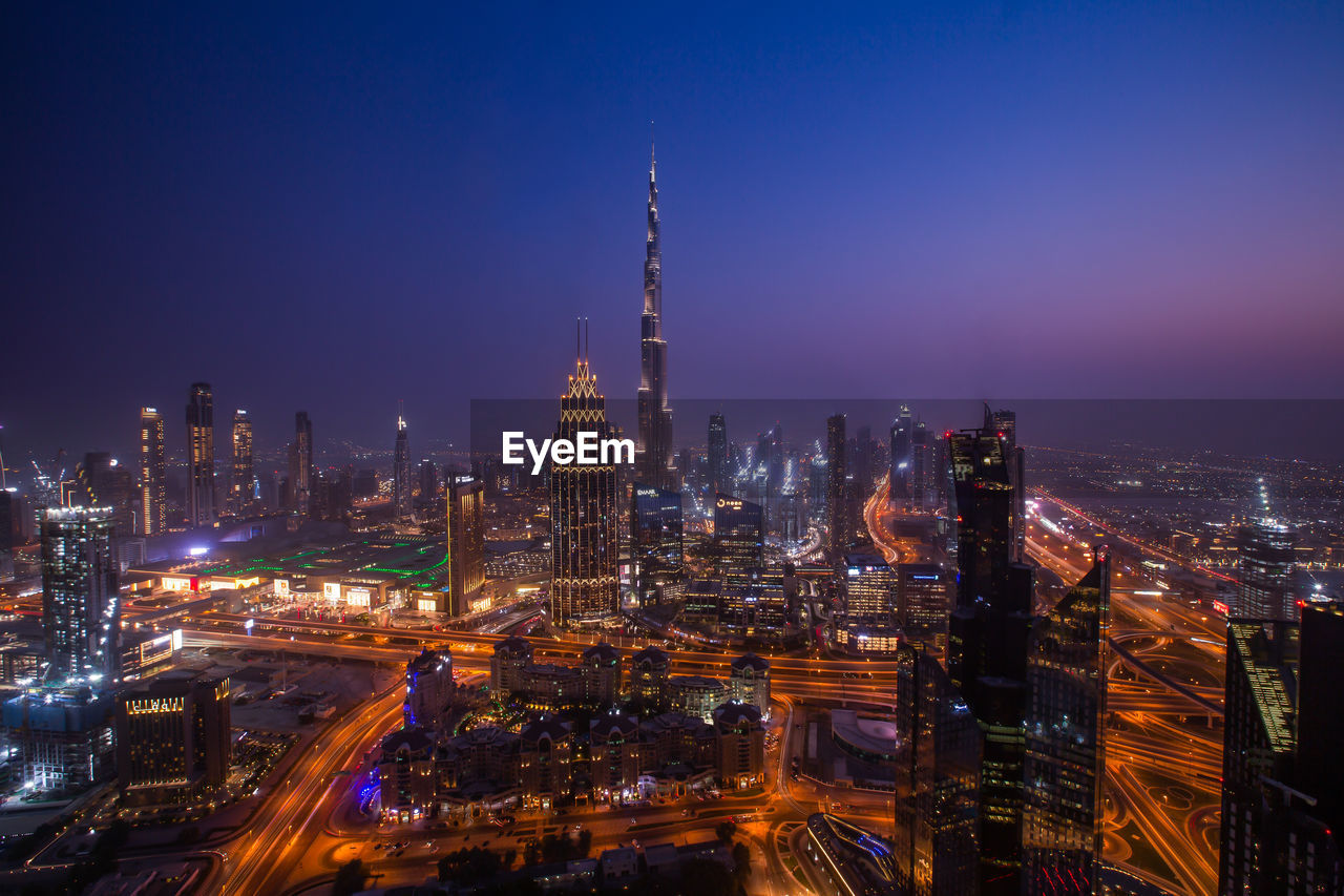 Illuminated city against sky at night