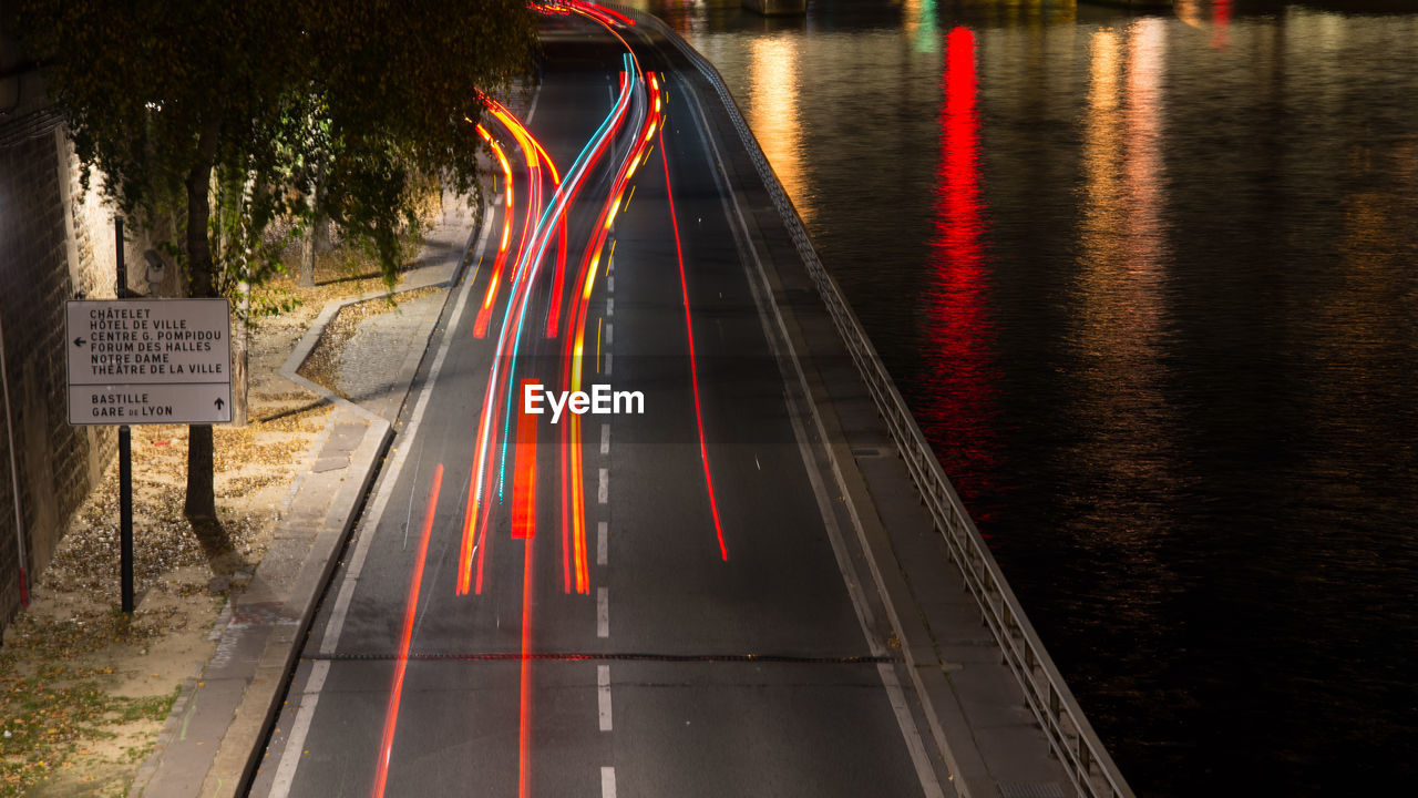 High angle view of light trails by river at night