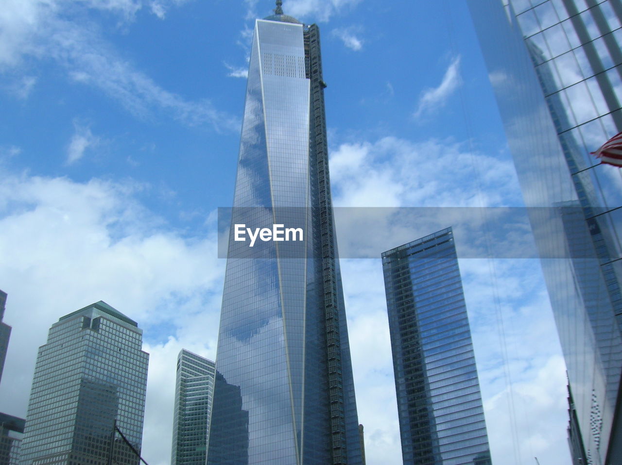 Low angle view of modern skyscrapers against cloudy sky