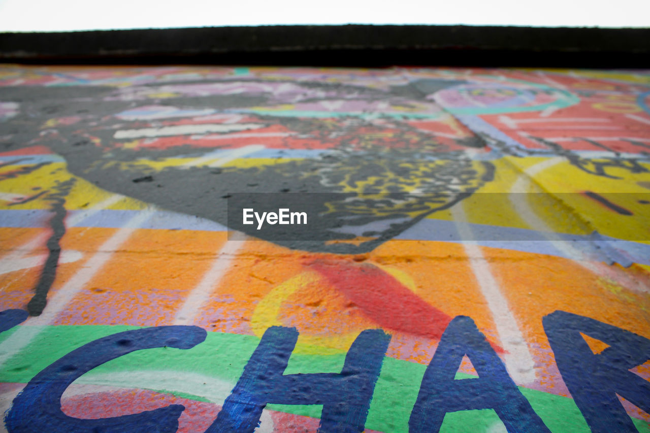 CLOSE-UP OF MULTI COLORED GRAFFITI ON CITY