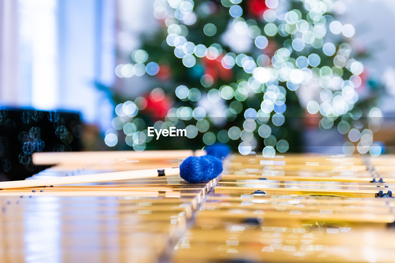 Vibraphone sticks lying on this percussion instrument. in the background lights of christmas tree.