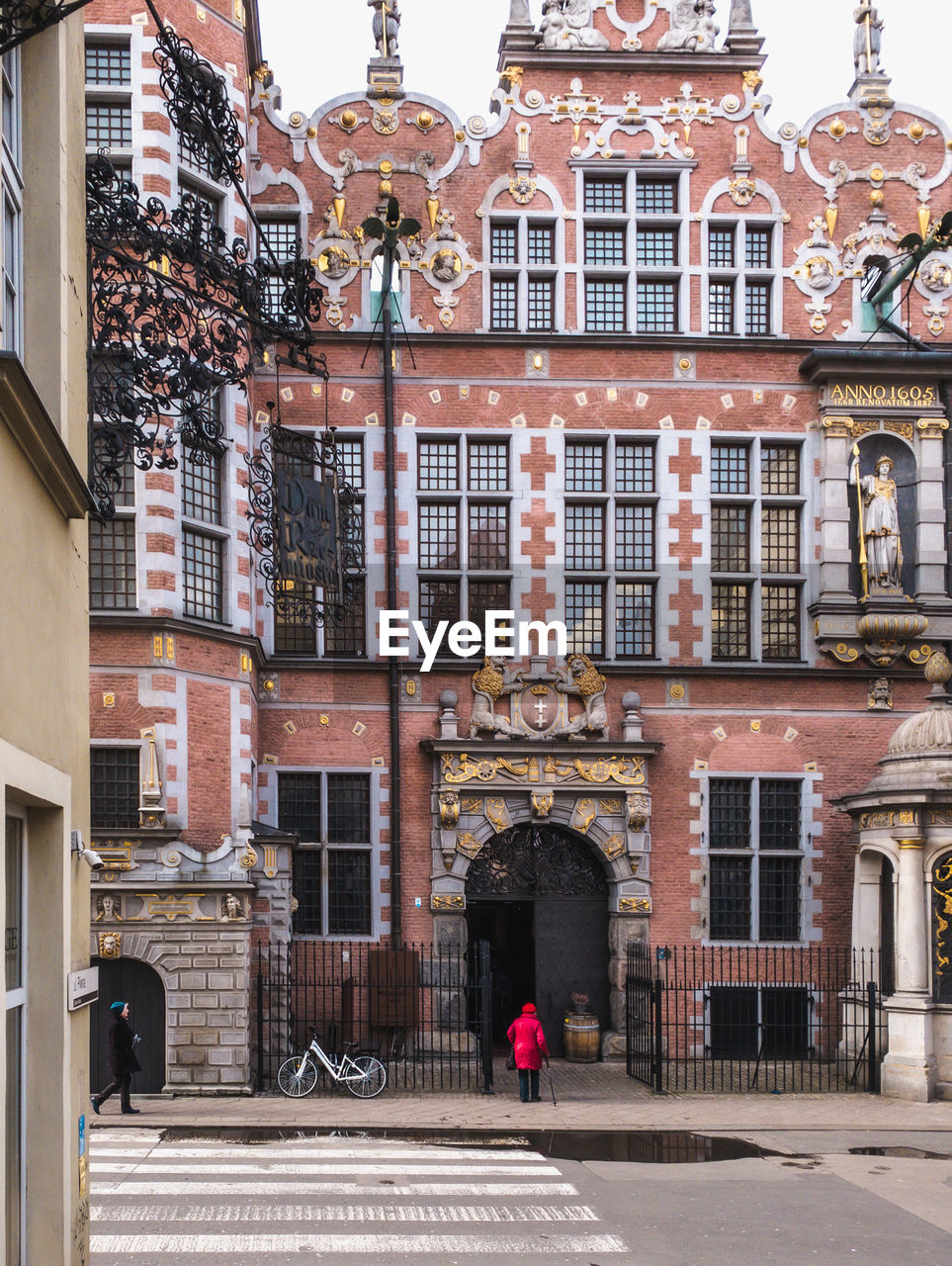 WOMAN WALKING ON STREET BY BUILDINGS