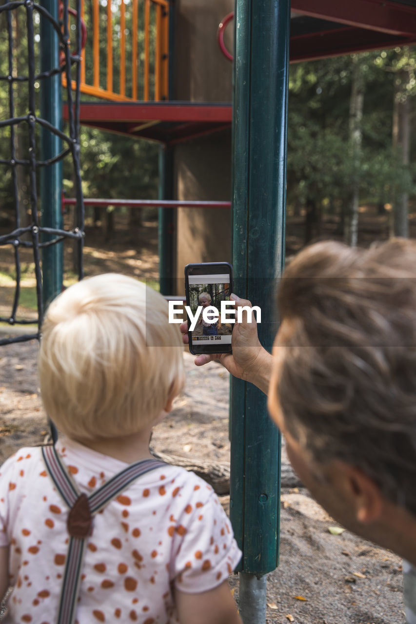 Father showing son picture on cell phone