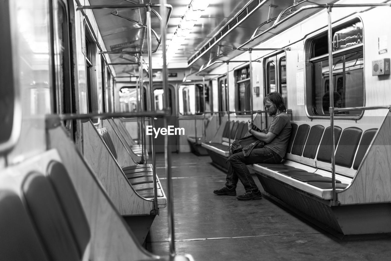 MAN SITTING IN TRAIN AT SUBWAY STATION