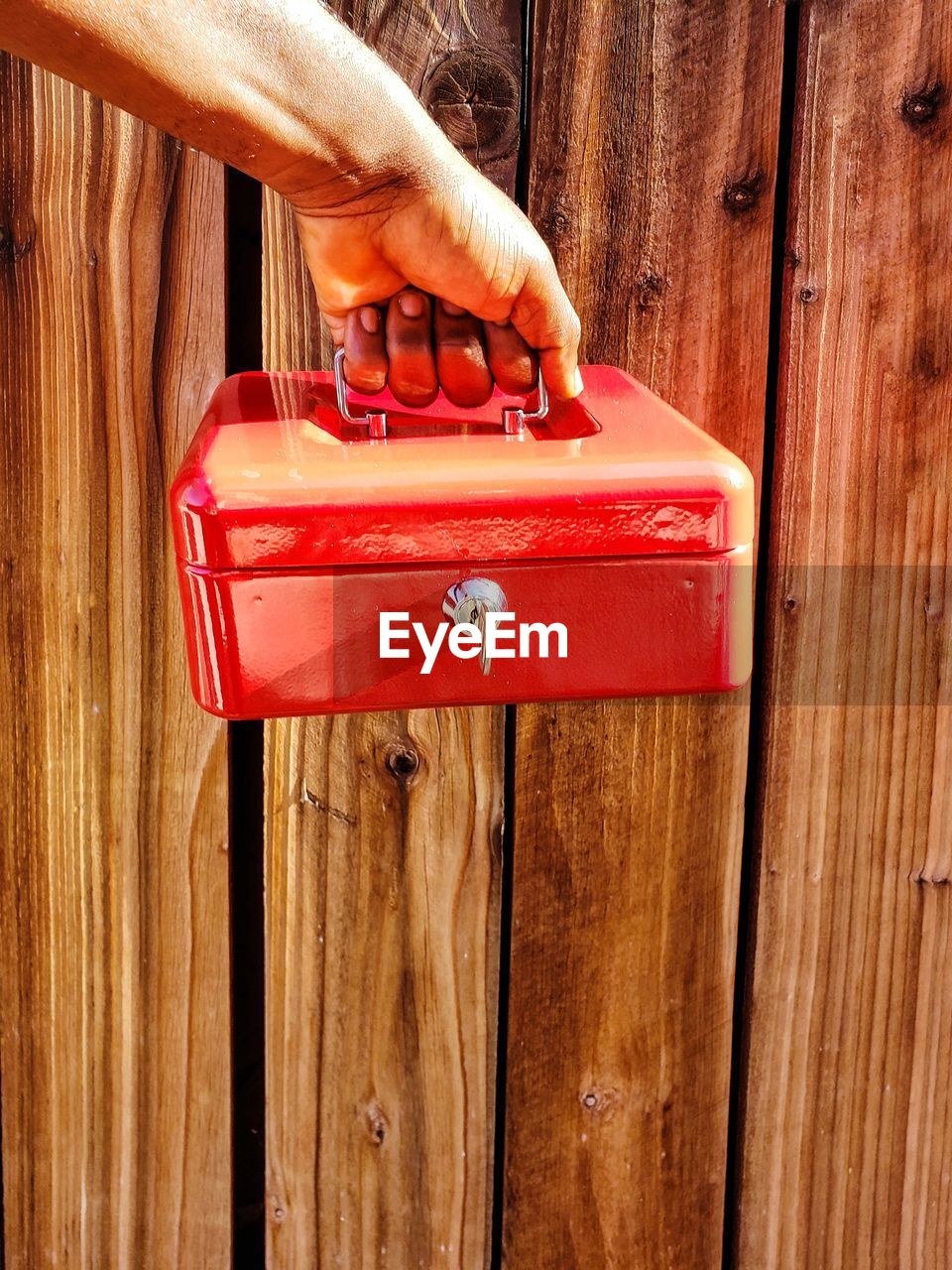 CLOSE-UP OF HAND HOLDING RED MAILBOX ON DOOR
