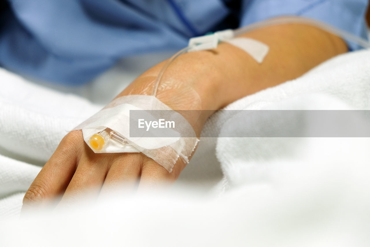 Close-up of woman hand with medical equipment on bed