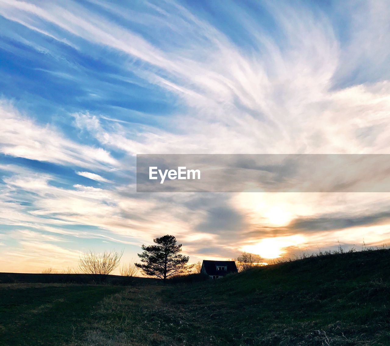 SCENIC VIEW OF SUNSET OVER FIELD