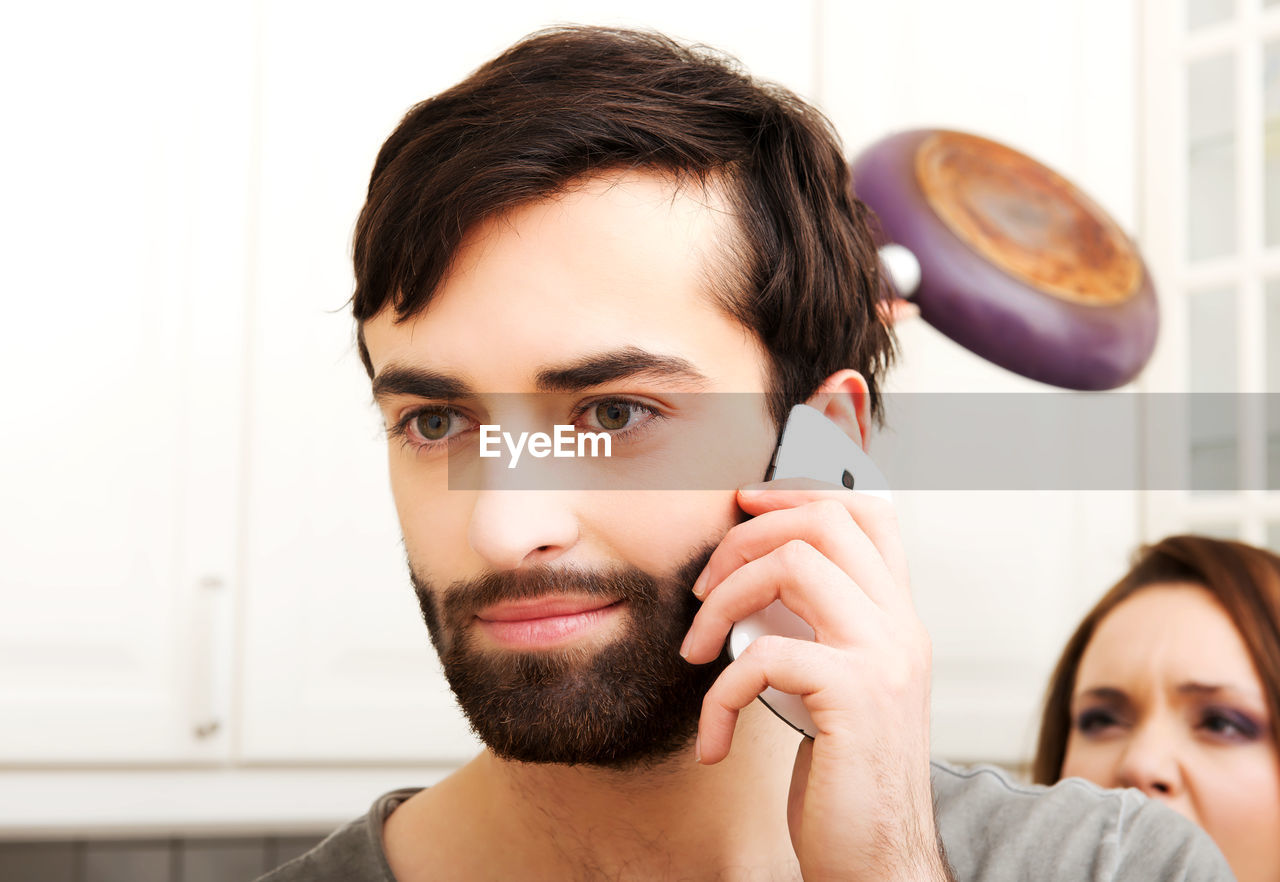 PORTRAIT OF YOUNG MAN LOOKING THROUGH CAMERA