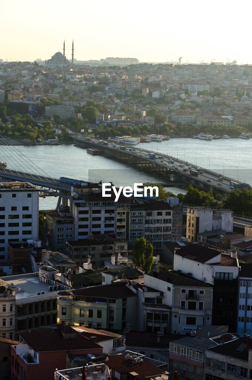 HIGH ANGLE VIEW OF RIVER AMIDST BUILDINGS IN CITY