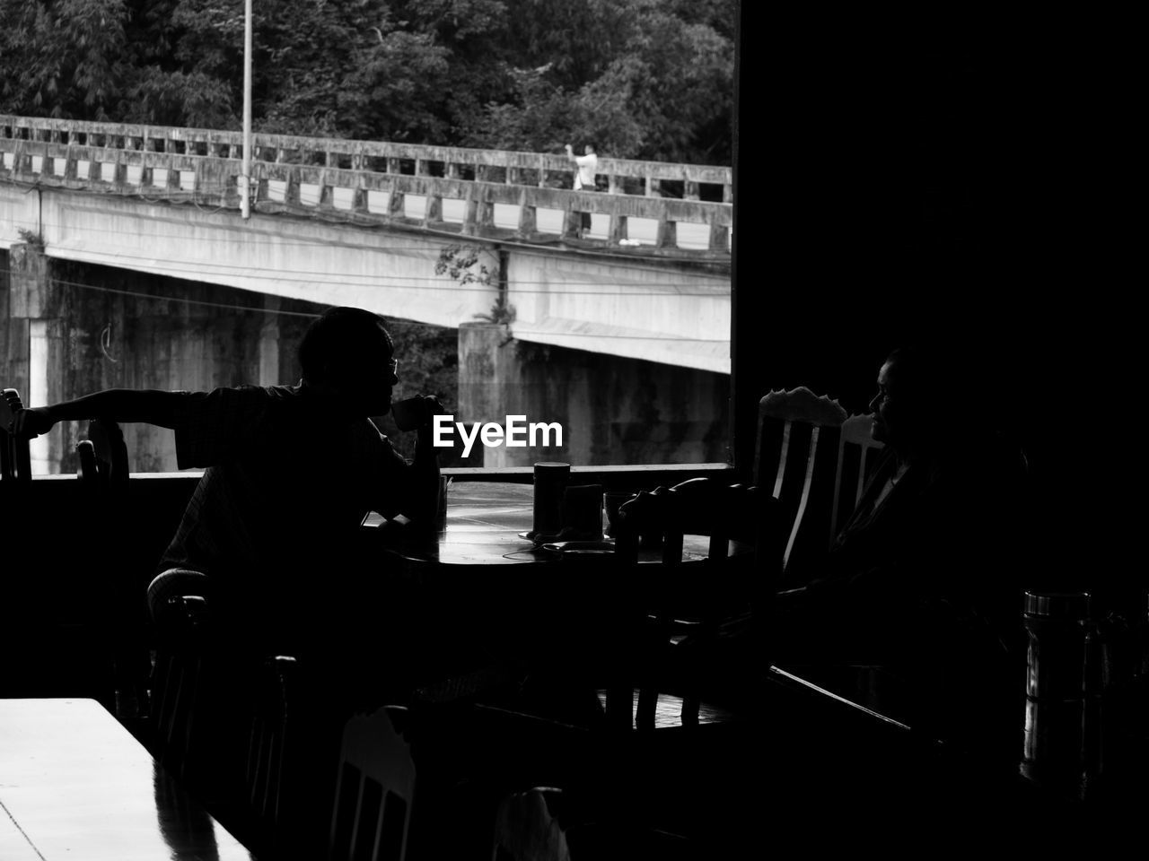 SILHOUETTE OF MAN SITTING ON CHAIR IN KITCHEN