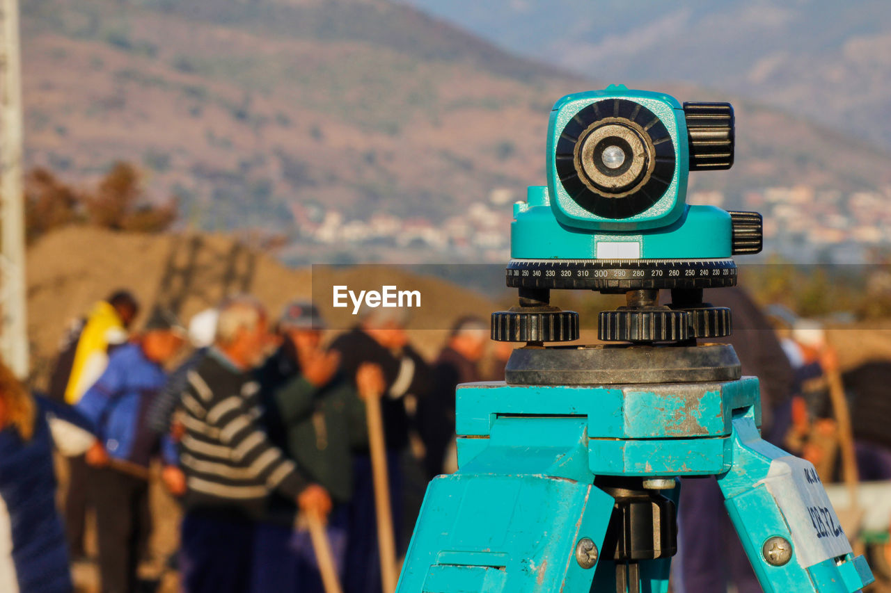 Optical level on a blurred background with workers working on a archaeological site