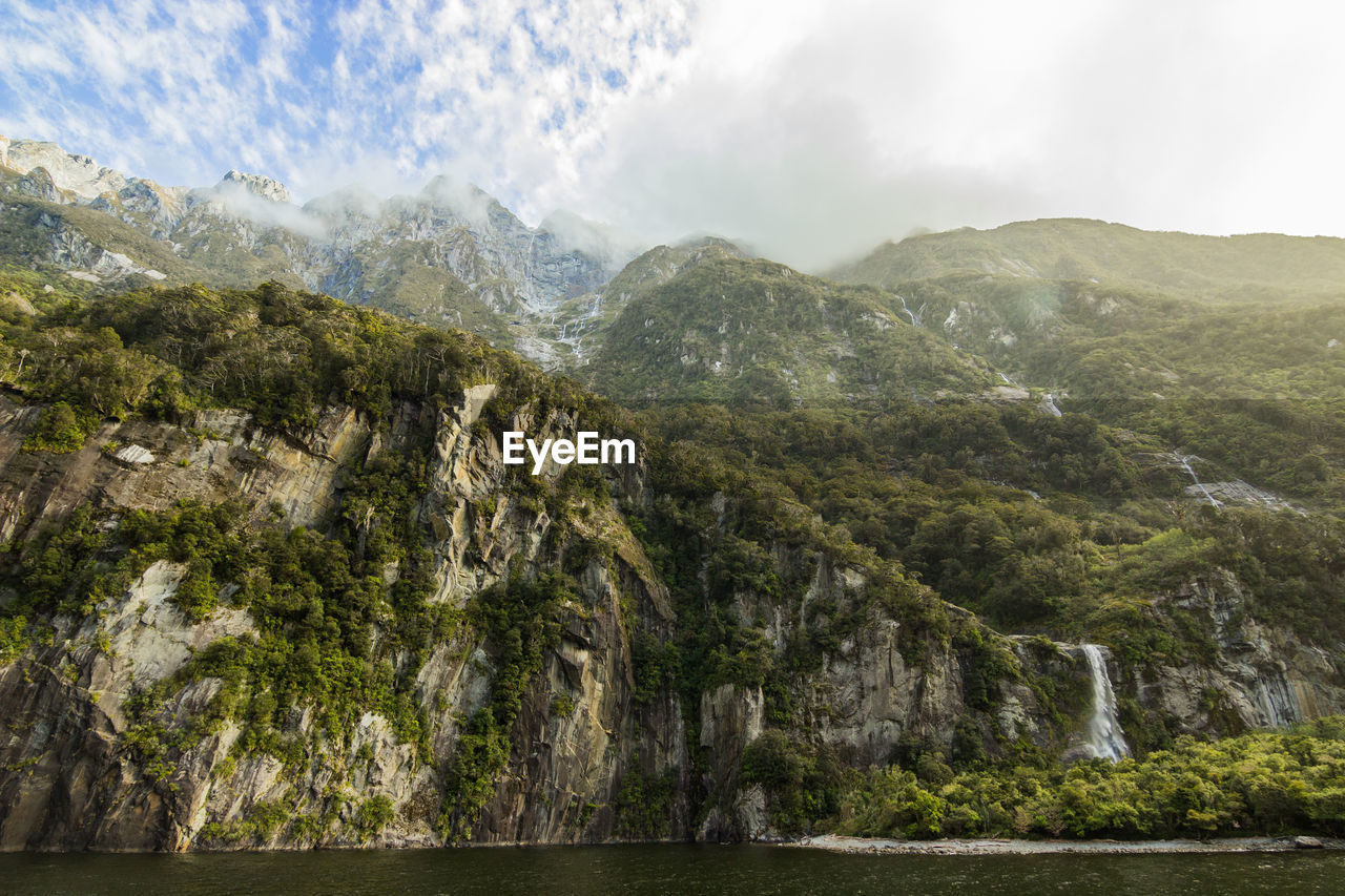 Low angle view of rocky mountains at milford sound